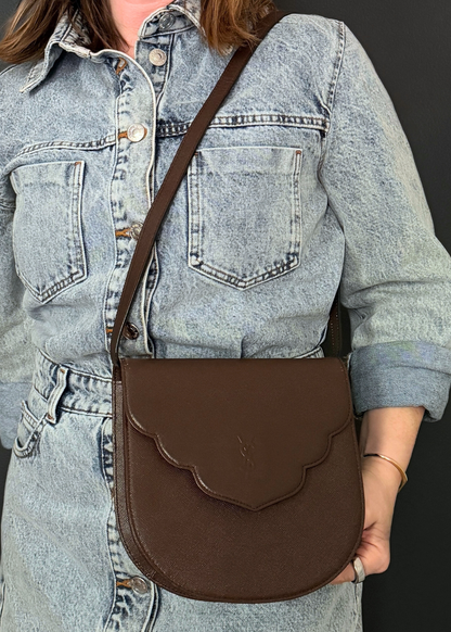 Person wearing a vintage brown leather Yves Saint Laurent crossbody bag
