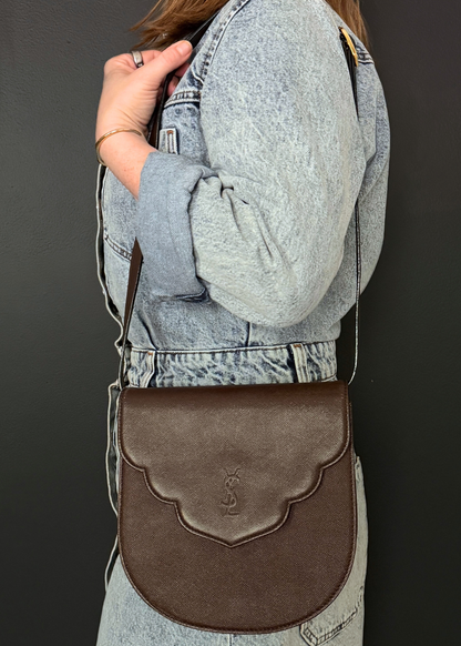Person wearing a vintage Yves Saint Laurent brown leather crossbody bag
