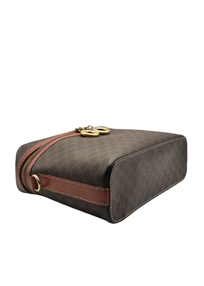 Brown leather vanity bag with a strap on a white background