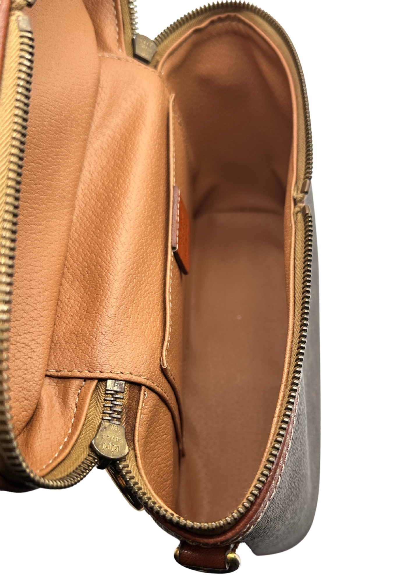 Close-up of a brown leather pouch with zippers on a white background