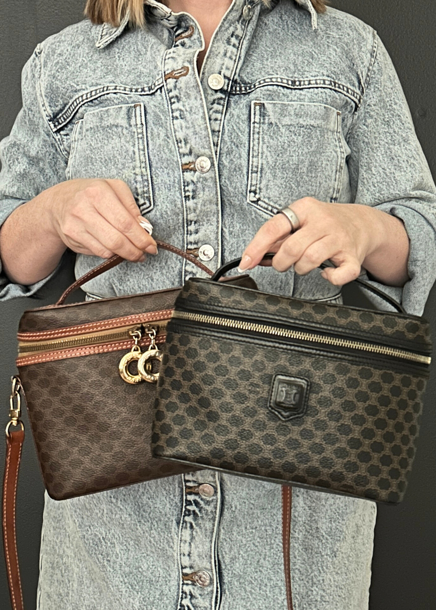 Person holding two Celine handbags, one with a visible brand logo, against a neutral background.