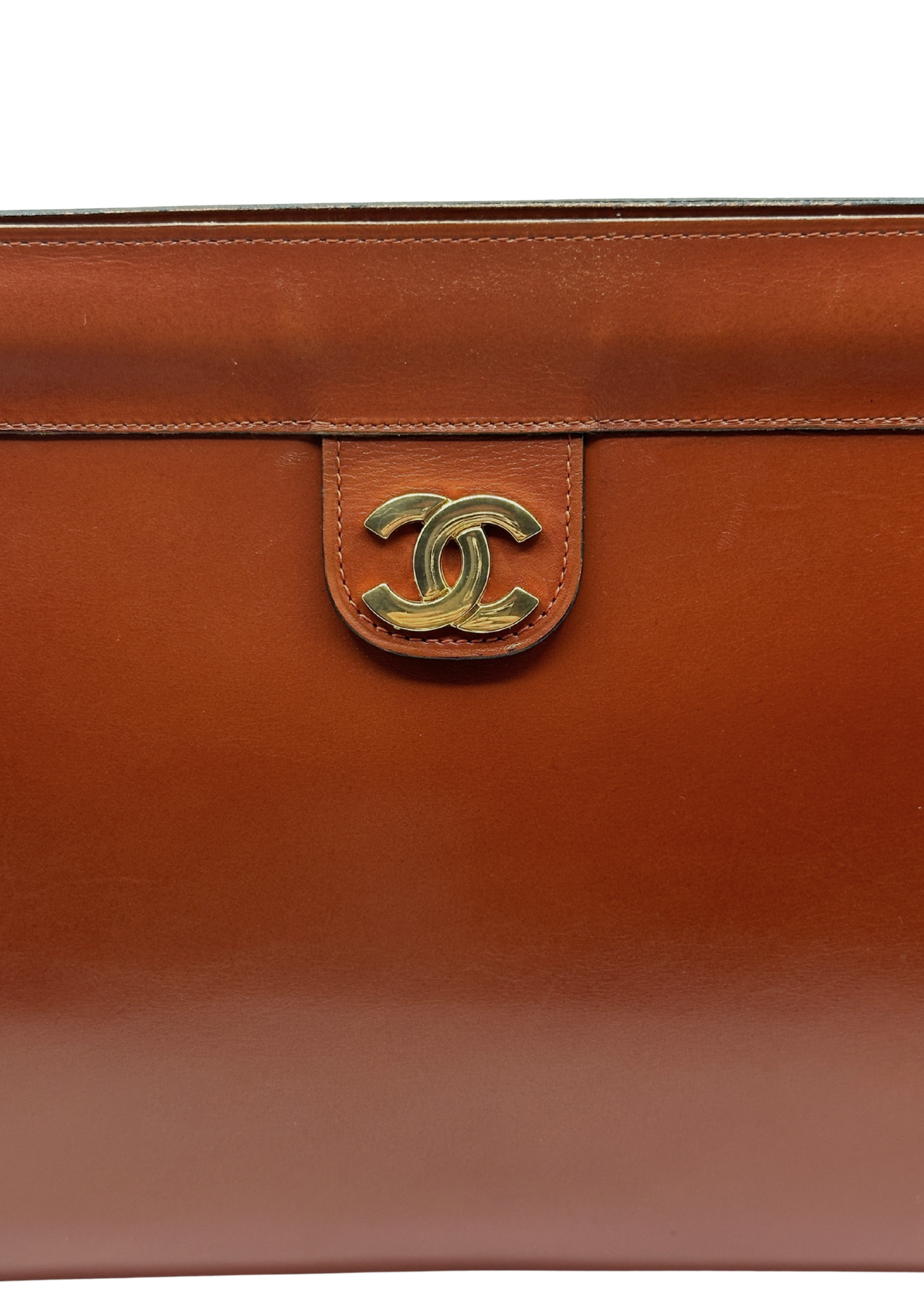 Brown leather handbag with gold CC Chanel logo on a white background