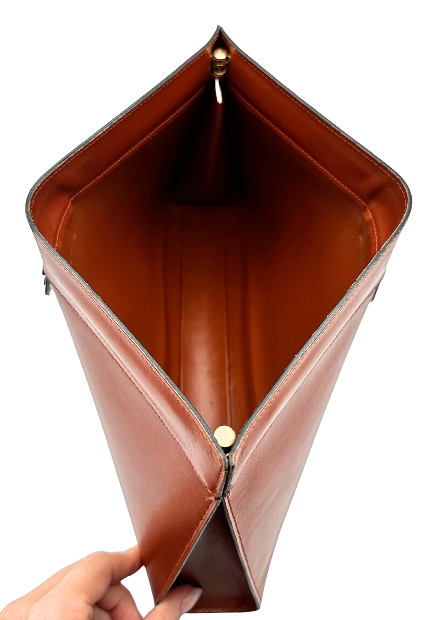 Brown leather Chanel clutch bag held open on a white background