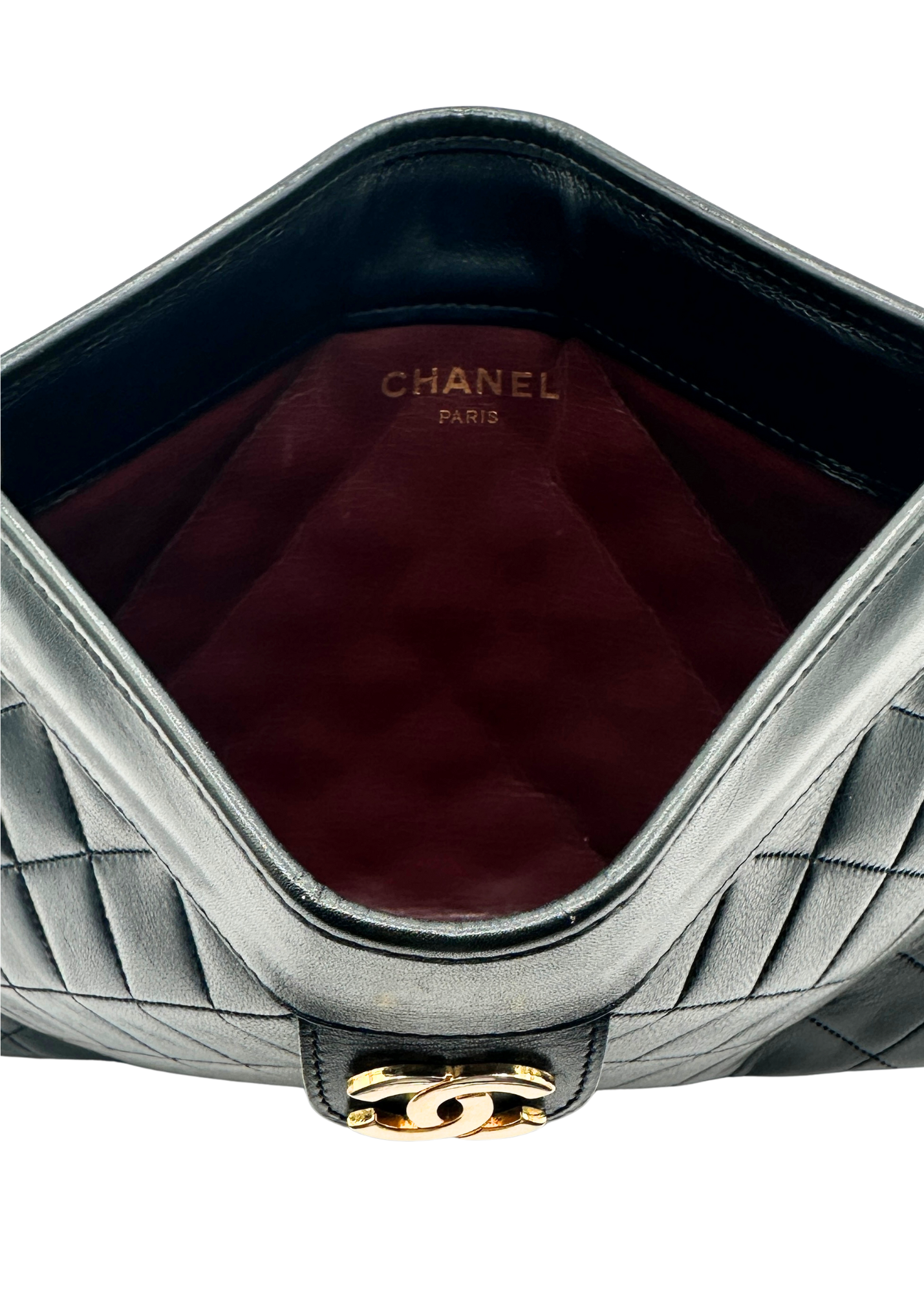 Close-up of a Chanel handbag with quilted design and gold hardware.