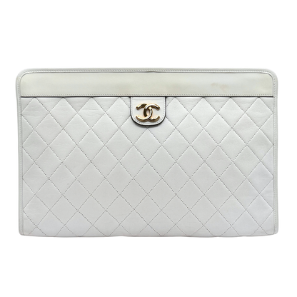 White quilted vintage Chanel handbag with gold hardware on a white background