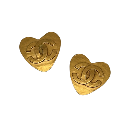 Gold heart-shaped earrings with a CC Chanel brand logo on a white background