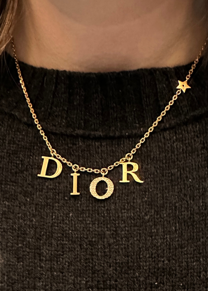 Gold 'Dior' necklace on a black background