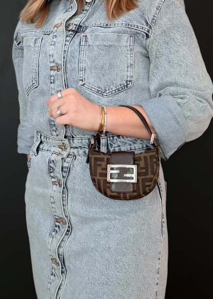 Person wearing a denim jacket and jeans with a vintage Fendi brown zucca patterned bag.