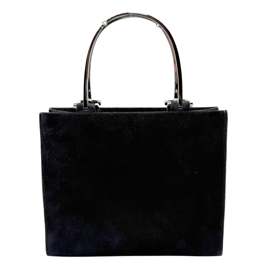 A black suede tote bag with a structured rectangular shape and a curved metallic silver horsebit handle, shown against a plain white background.