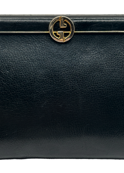 Black leather handbag with a gold Gucci GG logo on a white background