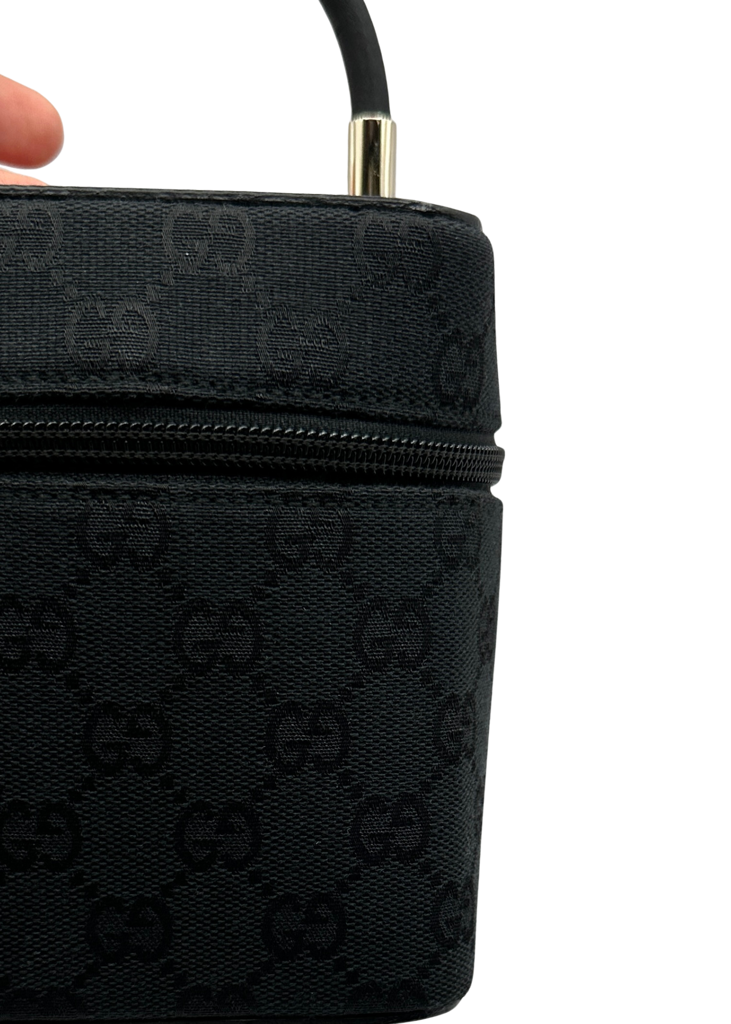 Black Gucci handbag with signature logo pattern on a white background