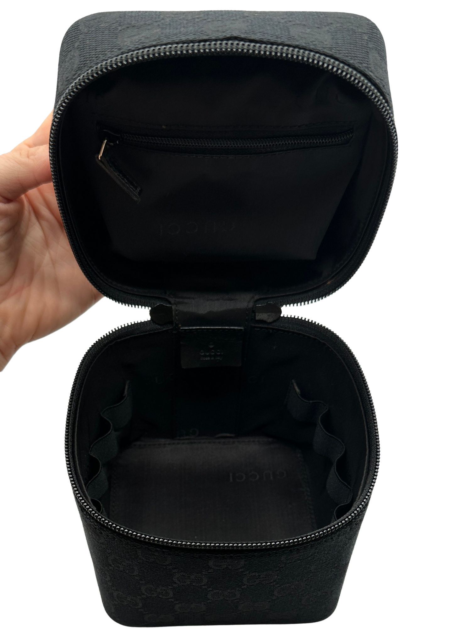 Black travel case with open lid held by a hand on a white background