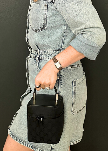 Person holding a black vintage Gucci box vanity bag