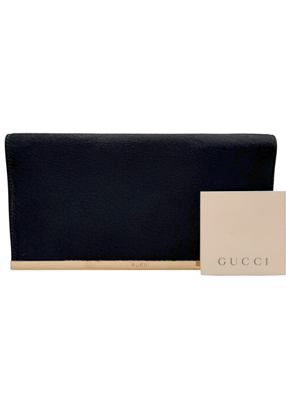 Black rare vintage clutch bag with a beige card featuring Gucci logo on a white background