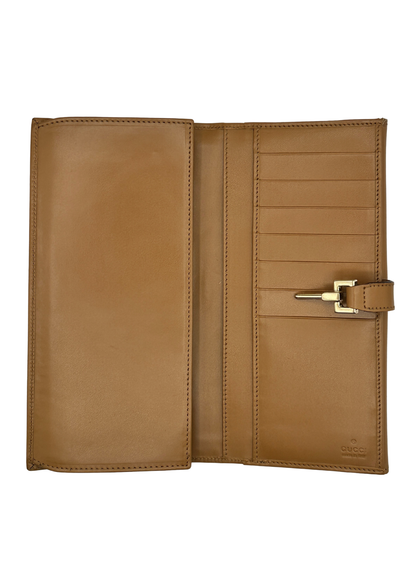 Brown Gucci leather wallet with gold buckle on a white background