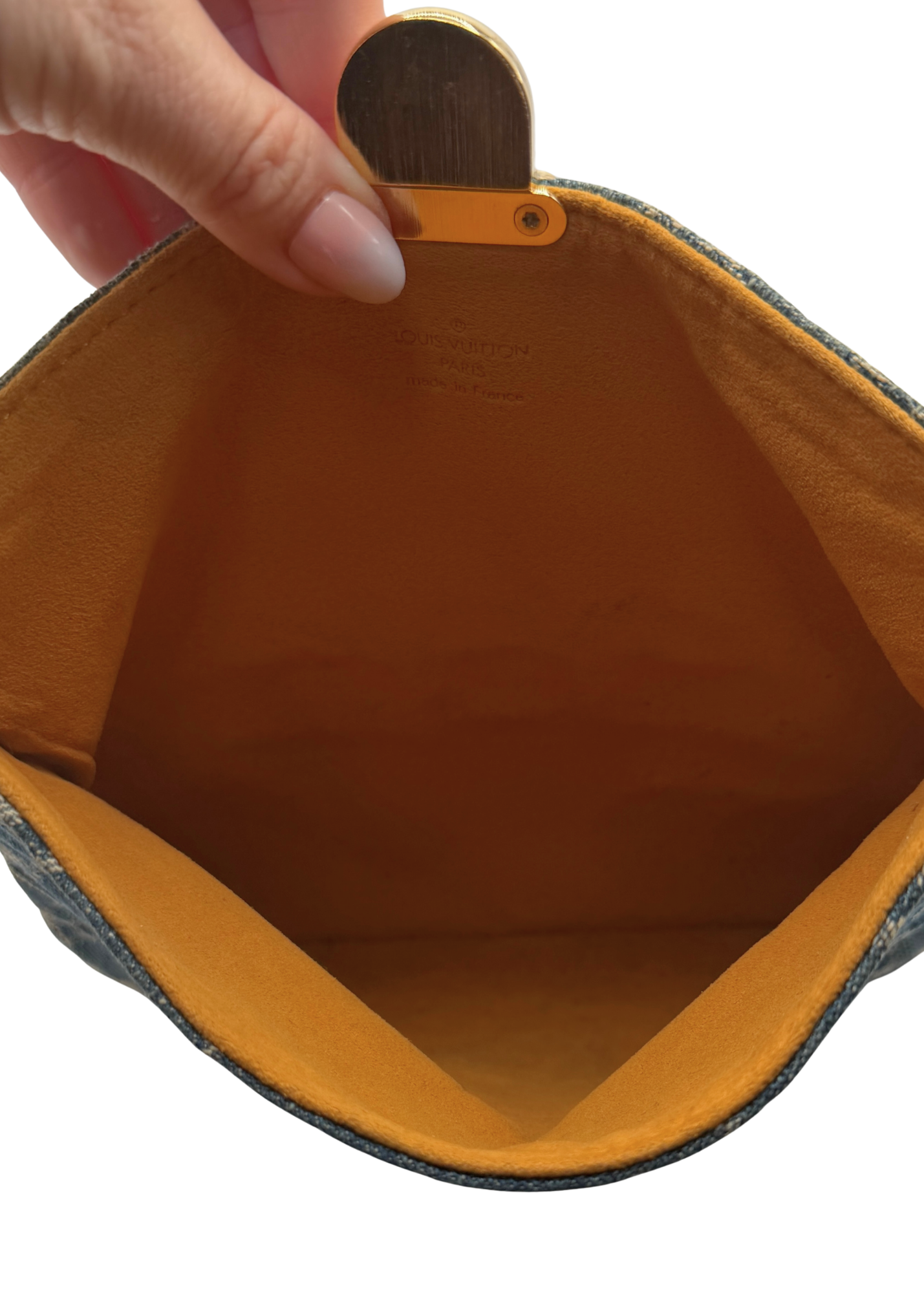 Close-up of a hand holding an open brown leather pouch with a visible brand name.