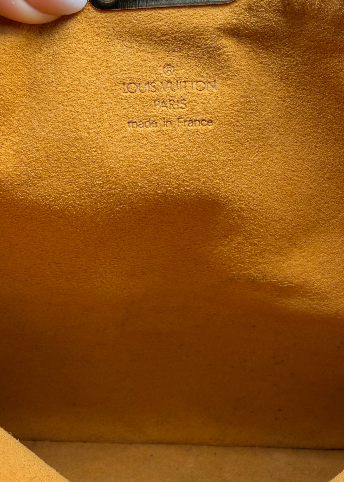Close-up of a Louis Vuitton bag with 'made in France' text on brown leather.
