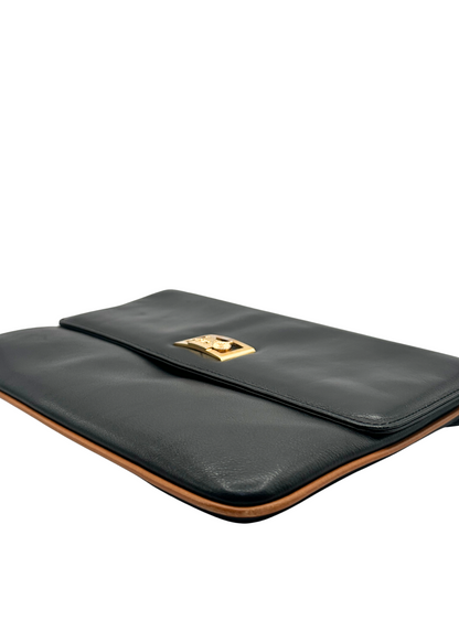Black leather Celine clutch bag with gold clasp on a white background