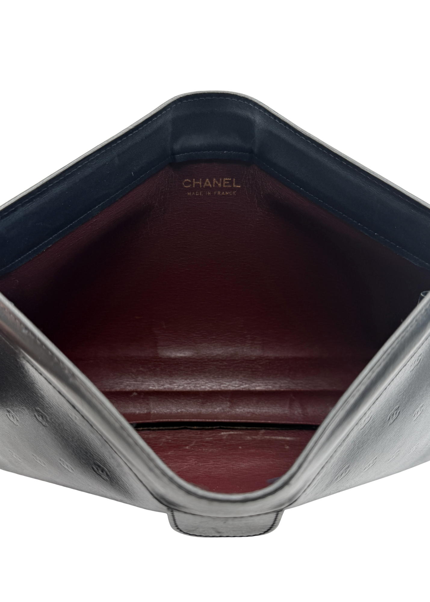Close-up of a Chanel clutch with a red leather interior and black exterior.