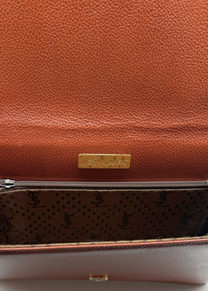 Brown vintage pebbled leather YSL clutch with a gold tag and patterned interior on a white background
