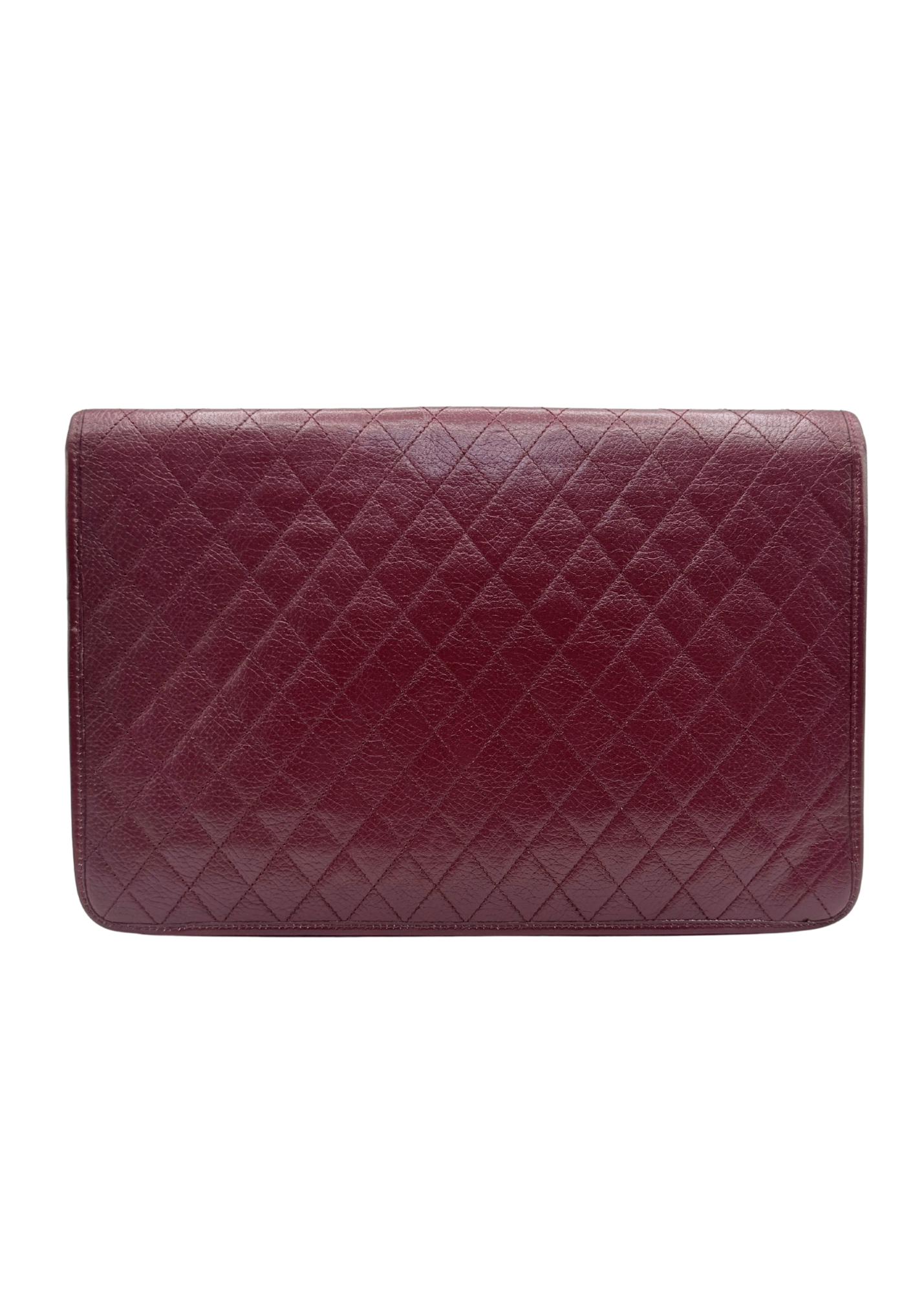 Vintage Yves Saint Laurent quilted burgundy leather clutch against white background