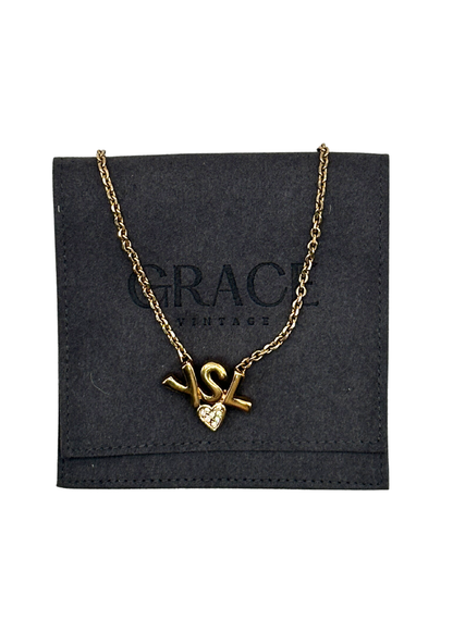 Gold vintage YSL necklace with heart pendant on a black 'GRACE' branded card
