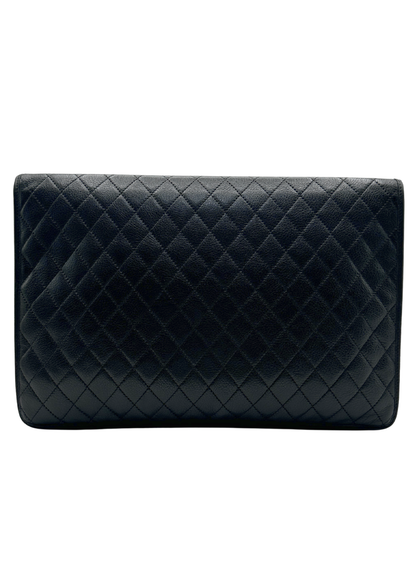 Black quilted YSL clutch bag on a white background