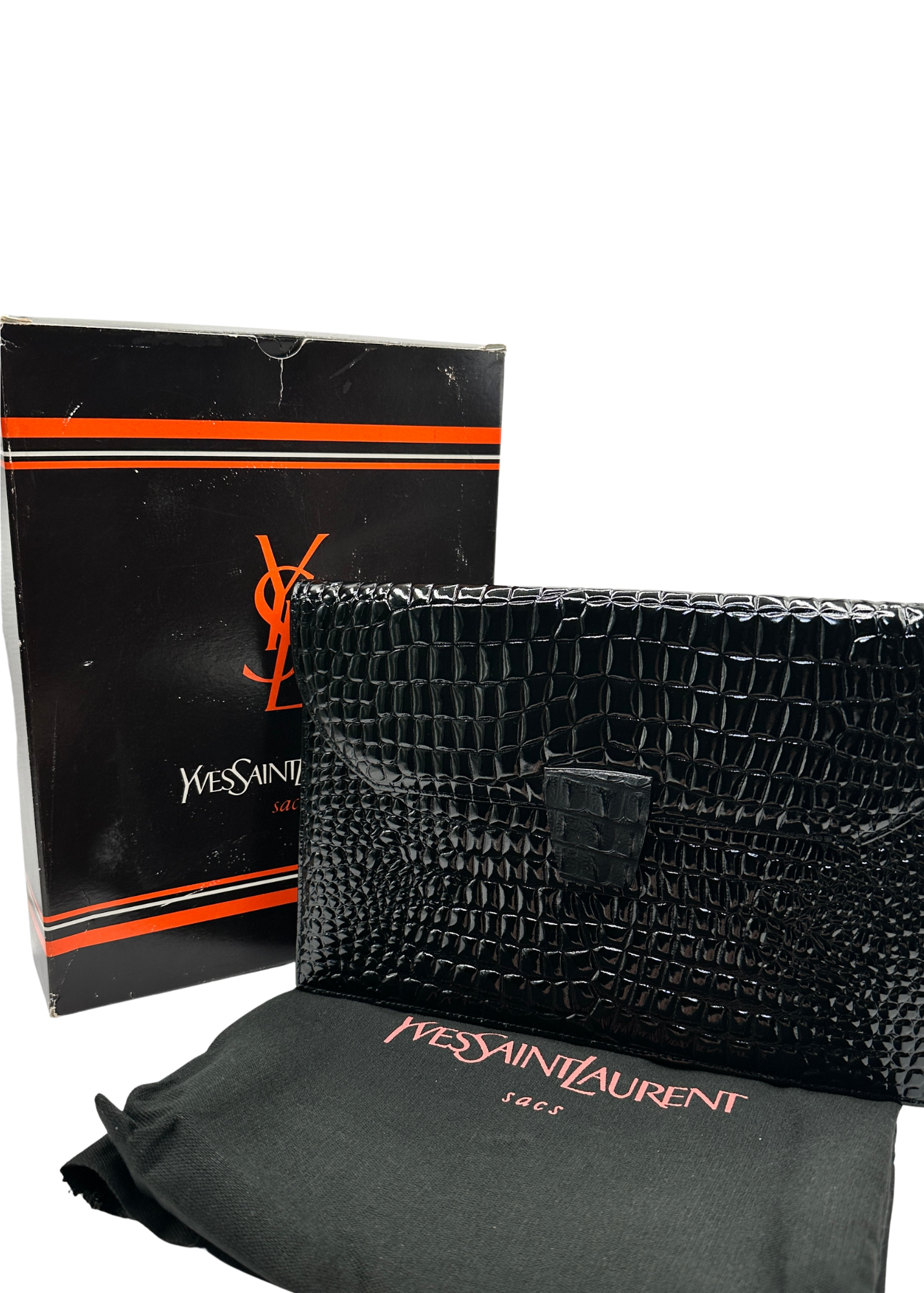 Black crocodile-patterned handbag with Yves Saint Laurent packaging on a white background